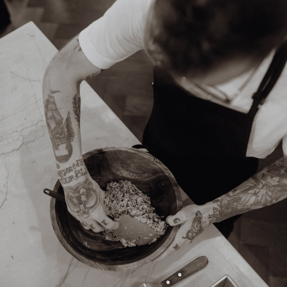 Person mixing ingredients in a bowl on a table