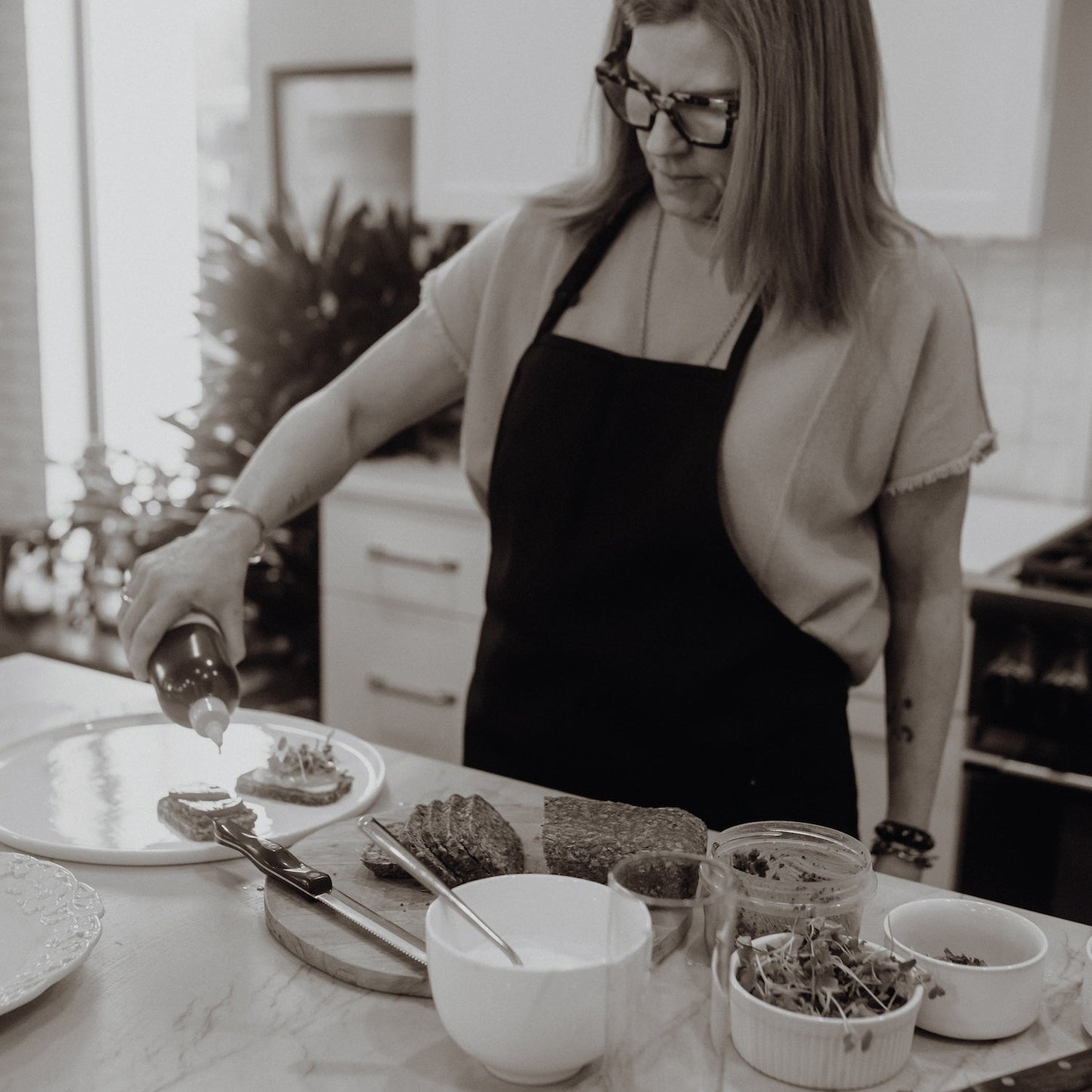 Person in a kitchen preparing food with various utensils and ingredients on a counter.