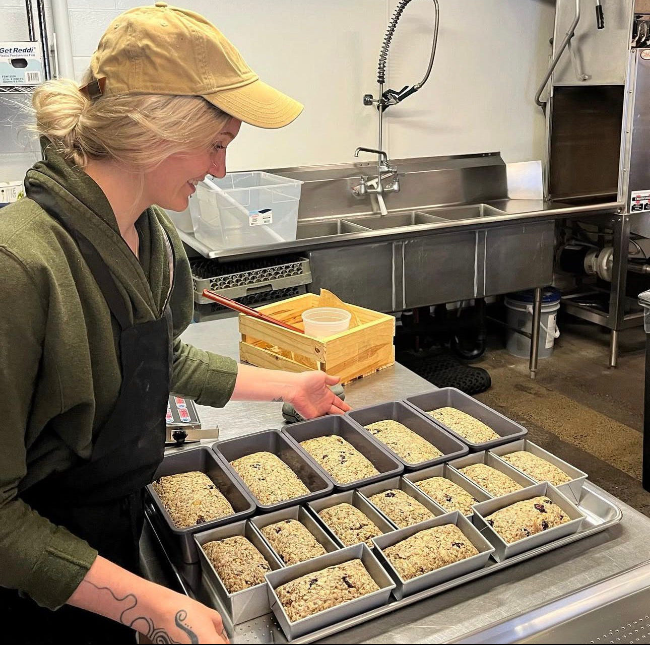Person in a kitchen preparing food in trays